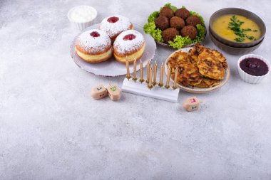 Geleneksel Yahudi bayramı Hanuka yemeği. Donut sufganiot, patates gözleme latke, falafel, mum ve dreidl!