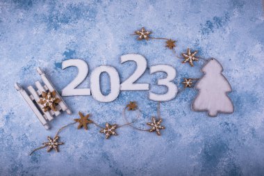 2023 Yeni Yıl ve Noel kompozisyonu ve mavi arka planda zencefilli kurabiyeler