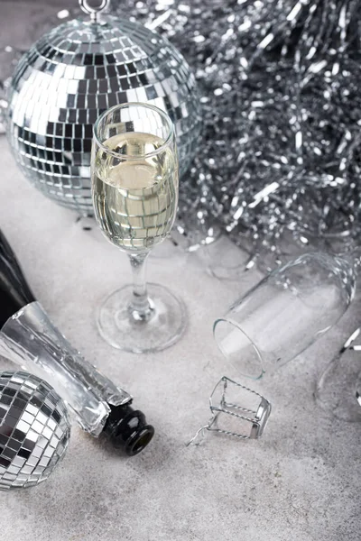 Glass of champagne with silver mirror disco ball. New year party composition