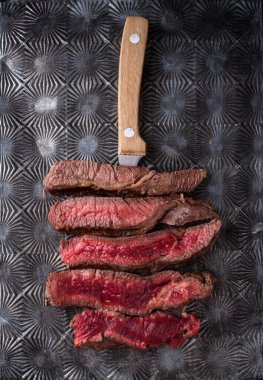 Different degrees of steak roasting. Steak with blood, medium to high roast steak on a wooden board