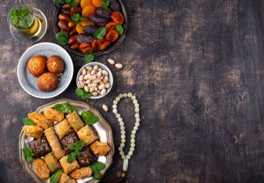 Ramadan iftar traditional desserts. Turkish and Arabic sweets baklava, pistachios, dates and dried apricots