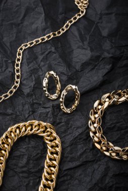 Golden chains earrings on black background. Jewelry photography concept