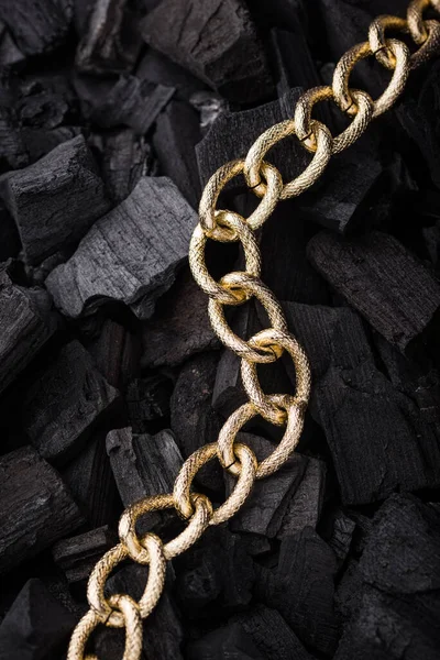 Golden chains earrings on black background. Jewelry photography concept