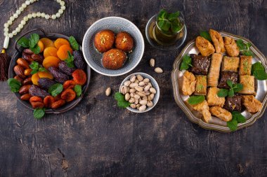 Ramadan iftar traditional desserts. Turkish and Arabic sweets baklava, pistachios, dates and dried apricots