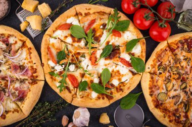 Assortment of various type of Italian pizza with bacon, chicken meat, soft cheese and tomato