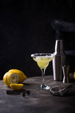 Limonlu margarita veya koyu arkaplanda martini kokteyli.