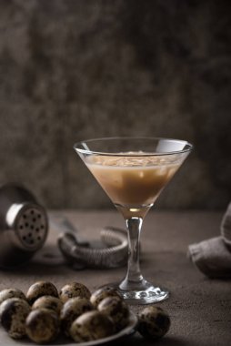 Kahverengi arka planda bıldırcın yumurtaları olan kremalı çikolatalı alkolik kokteyl.