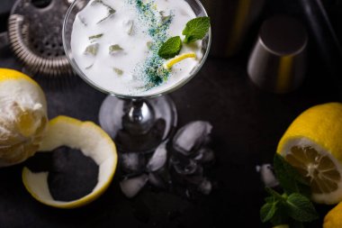 Siyah arka planda limonlu kokteyl ve nane şekeri.