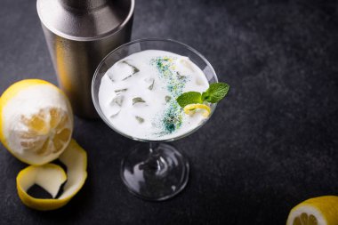 Siyah arka planda limonlu kokteyl ve nane şekeri.