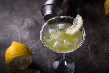 Limonlu margarita veya koyu arkaplanda martini kokteyli.