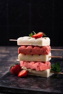 Siyah arka planda naneli çilekli dondurma.