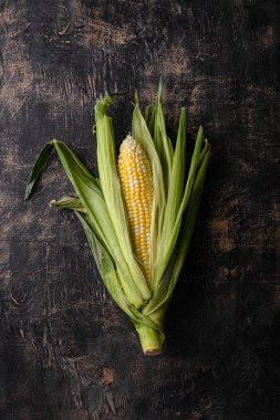 Siyah arka planda çiğ mısır. Karanlık ruh hali sade anahtar tarzı