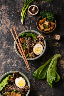 Soba eriştesi, tofu ve mantarlı koyu arkaplan.