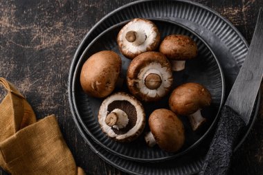 Siyah arka planda pişmemiş şampiyon mantarları.