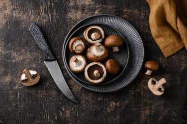 Siyah arka planda pişmemiş şampiyon mantarları.