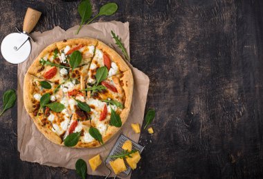 Italian home made pizza with feta cheese, tomato and basil