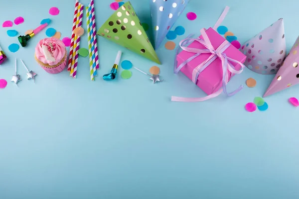 Birthday party concept with cupcake, confetti and garland