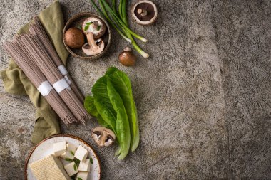 Çiğ soba eriştesi, pişirme malzemesi tofu ve mantar.