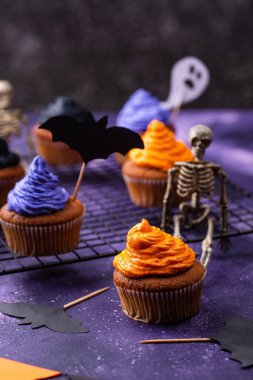 Siyah, mor, turuncu kremalı ve dekorlu Cadılar Bayramı kekleri.