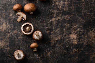 Siyah arka planda pişmemiş şampiyon mantarları.