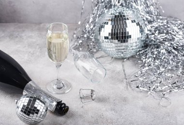 Glass of champagne with silver mirror disco ball. New year party composition