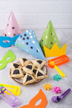 Jewish holiday Purim with carnival mask, traditional cookies Hamantaschen and rattle