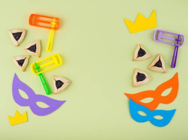 Jewish holiday Purim with carnival mask, traditional cookies Hamantaschen and rattle