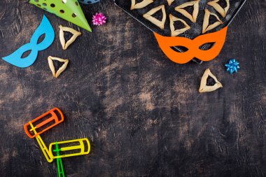 Jewish holiday Purim with carnival mask, traditional cookies Hamantaschen and rattle