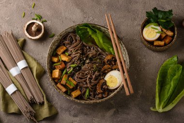 Soba eriştesi, tofu ve mantarlı koyu arkaplan.