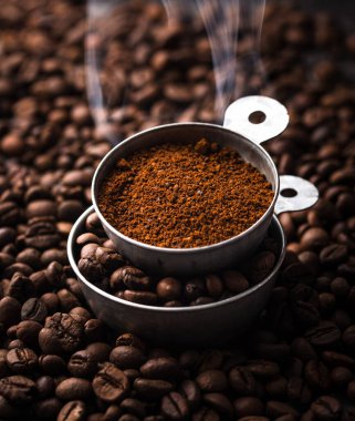 Topraklanmış kahve, fasulye, kahve makinesi ve farklı baharatlar.