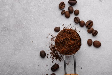 Topraklanmış kahve, fasulye, kahve makinesi ve farklı baharatlar.