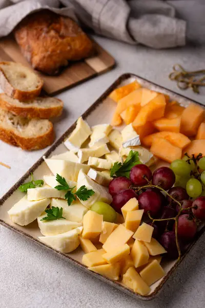 Farklı peynirli, üzümlü ve kavunlu peynir tabağı. Şarap için aperatif veya antipasti.