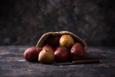Çiğ pişmemiş taze patates kara masada.