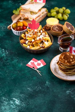 Kanada Günü geleneksel gıda konsepti. Poutine, tereyağlı tart, sandviç, akçaağaç şuruplu Kanada gözlemesi.
