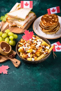 Kanada Günü geleneksel gıda konsepti. Poutine, tereyağlı tart, sandviç, akçaağaç şuruplu Kanada gözlemesi.