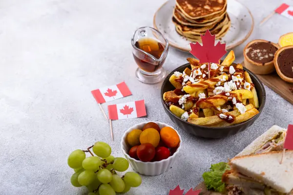 Kanada Günü geleneksel gıda konsepti. Poutine, tereyağlı tart, sandviç, akçaağaç şuruplu Kanada gözlemesi.