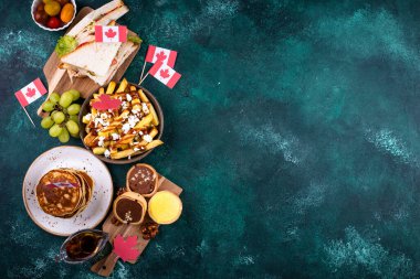 Kanada Günü geleneksel gıda konsepti. Poutine, tereyağlı tart, sandviç, akçaağaç şuruplu Kanada gözlemesi.