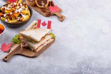 Kanada Günü geleneksel gıda konsepti. Poutine, tereyağlı tart, sandviç, akçaağaç şuruplu Kanada gözlemesi.