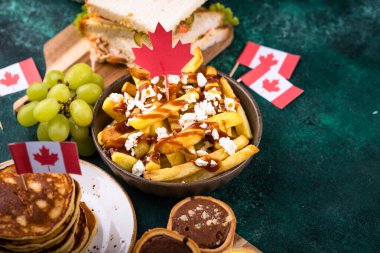 Kanada Günü geleneksel gıda konsepti. Poutine, tereyağlı tart, sandviç, akçaağaç şuruplu Kanada gözlemesi.