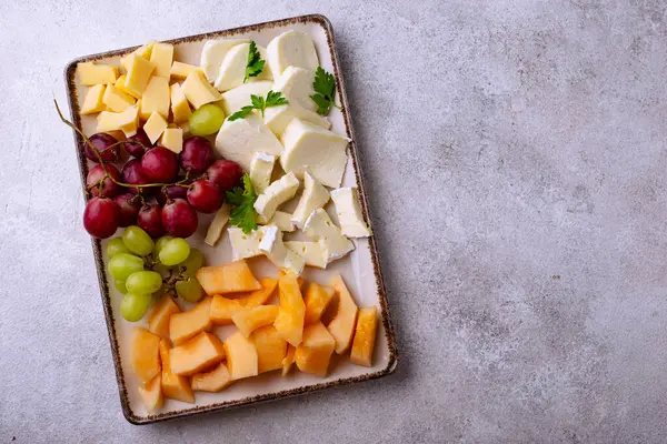 Farklı peynirli, üzümlü ve kavunlu peynir tabağı. Şarap için aperatif veya antipasti.