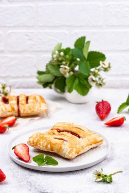 Beyaz arka planda çilekli tatlı puf börekler.