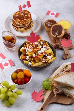 Kanada Günü geleneksel gıda konsepti. Poutine, tereyağlı tart, sandviç, akçaağaç şuruplu Kanada gözlemesi.