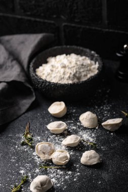 Çiğ mantı ya da siyah arka planda etli ravioli.