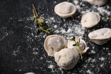 Çiğ mantı ya da siyah arka planda etli ravioli.