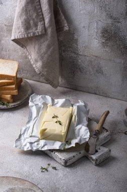 Gri arka planda taze tereyağı. Süt ürünü.