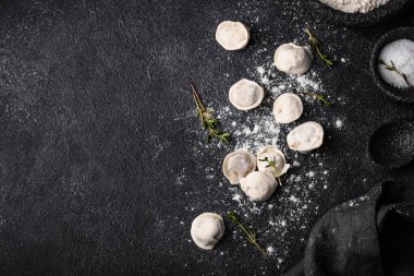 Çiğ mantı ya da siyah arka planda etli ravioli.