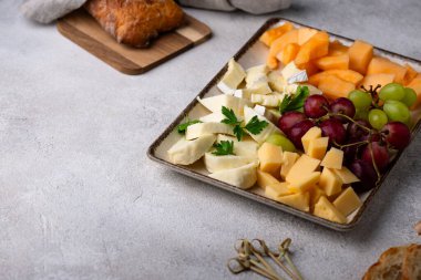 Farklı peynirli, üzümlü ve kavunlu peynir tabağı. Şarap için aperatif veya antipasti.