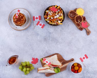 Kanada Günü geleneksel gıda konsepti. Poutine, tereyağlı tart, sandviç, akçaağaç şuruplu Kanada gözlemesi.