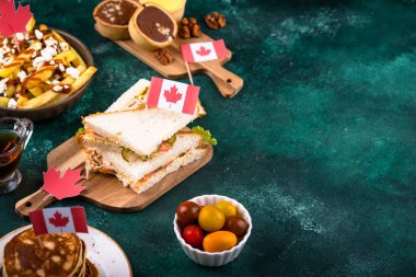 Kanada Günü geleneksel gıda konsepti. Poutine, tereyağlı tart, sandviç, akçaağaç şuruplu Kanada gözlemesi.