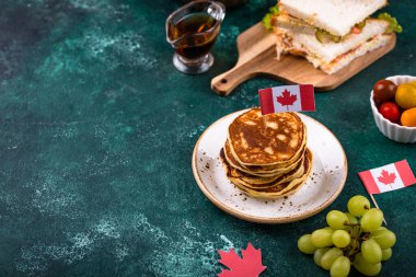 Kanada Günü geleneksel gıda konsepti. Poutine, tereyağlı tart, sandviç, akçaağaç şuruplu Kanada gözlemesi.